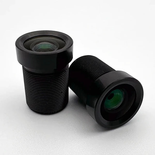 Zwei 8-mm-M12-Plattenobjektive von Commonlands: eines steht aufrecht und zeigt die beschichtete Frontlinse, das andere liegt auf der Seite und zeigt den Objektivtubus mit M12x0,5-Gewinde.