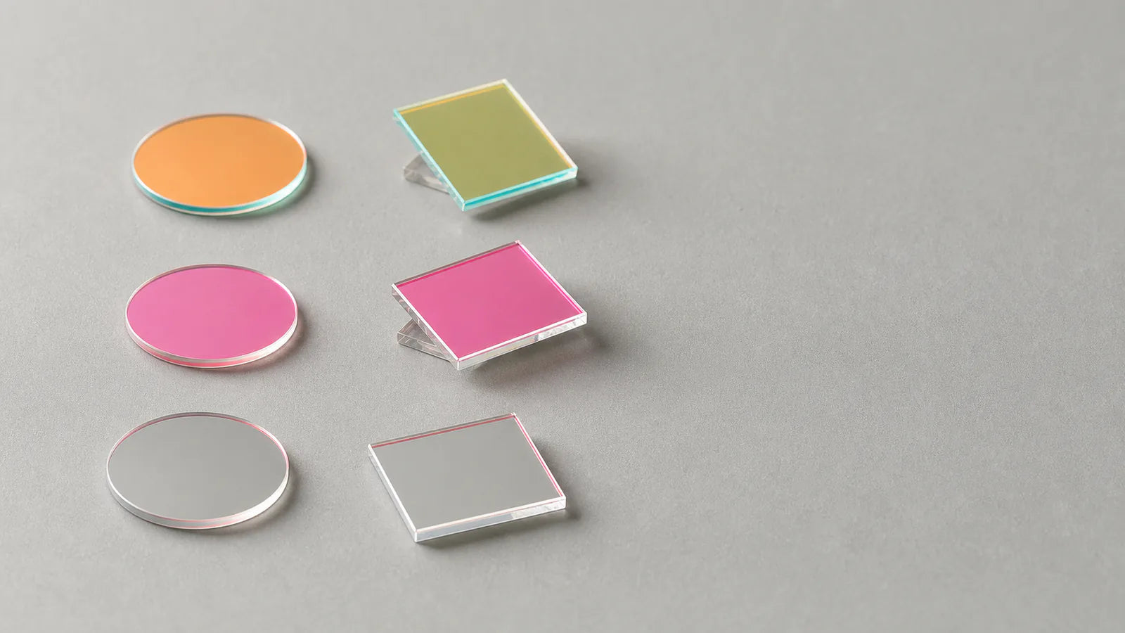 Commonlands machine vision bandpass filters beside an M12 lens, dichroic coatings reflecting color