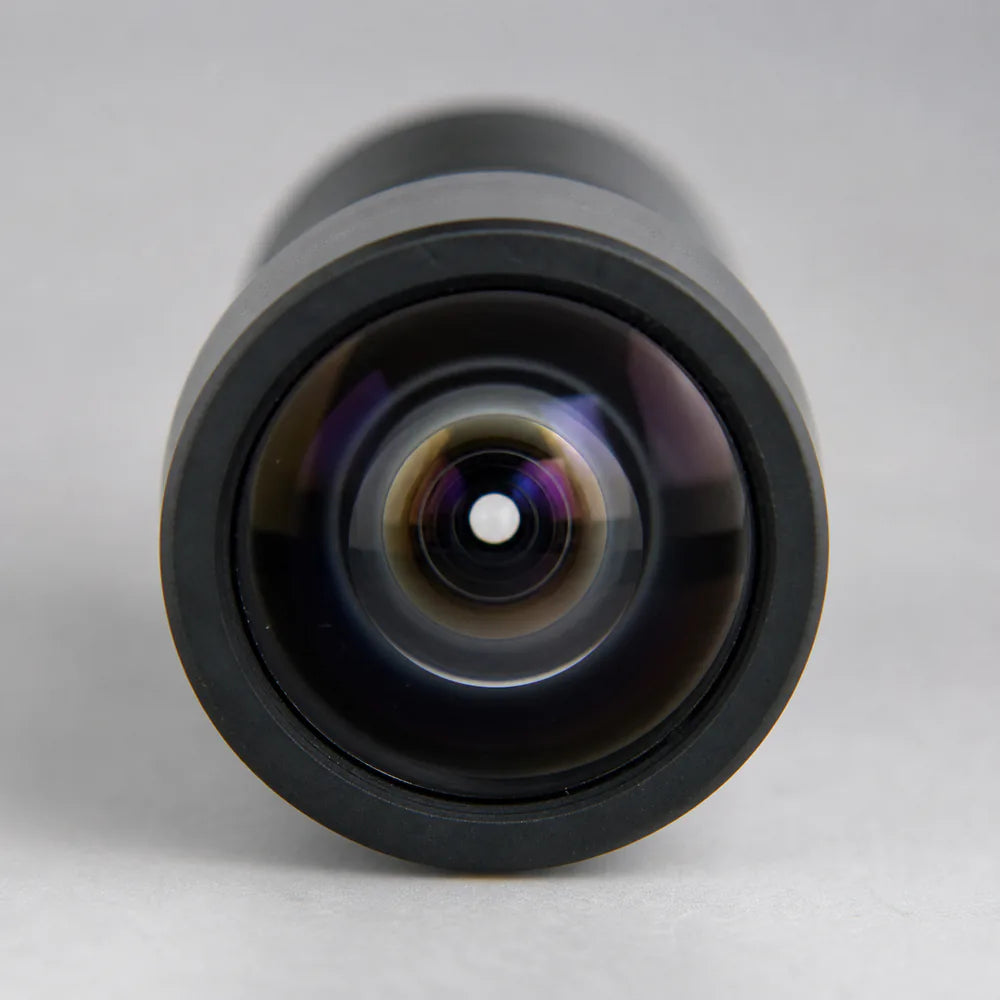 Looking into a Commonlands M12 lens at the bright circular entrance pupil deep in the barrel