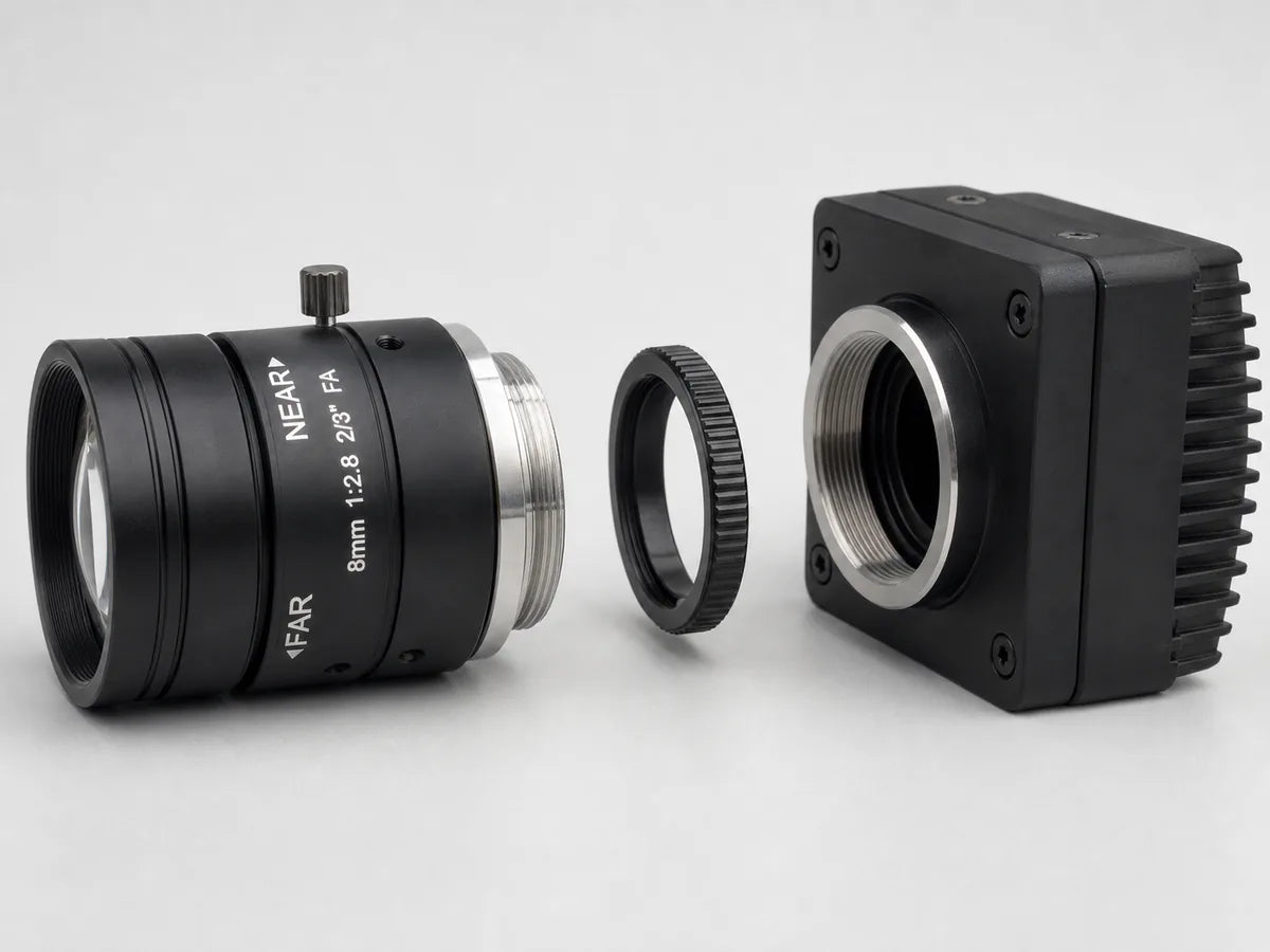 A C-mount to CS-mount adapter ring sitting between a C-mount lens and camera mount