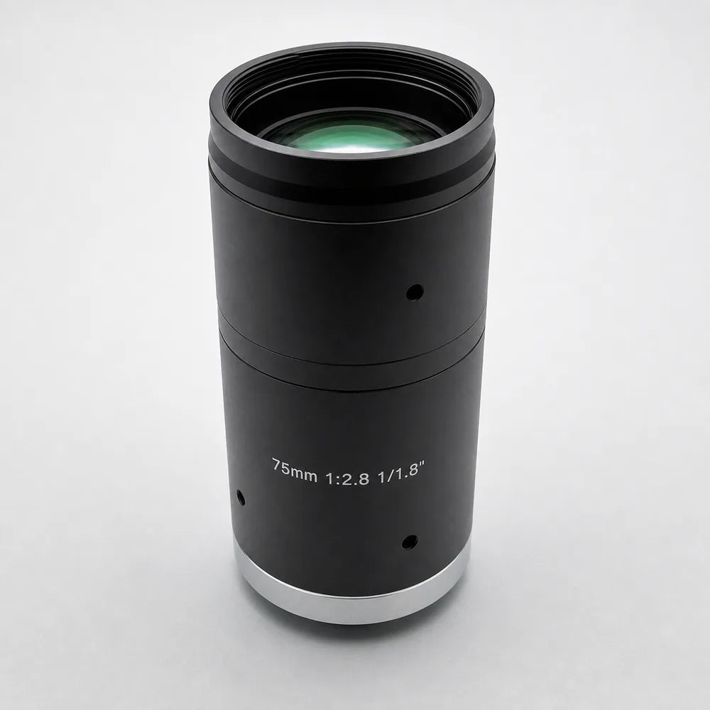 A Commonlands telephoto C-mount lens with a manual iris ring on a gray surface