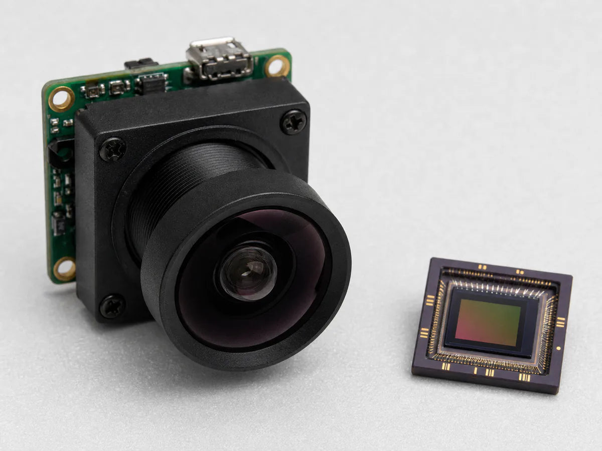 A Commonlands M12 lens threaded onto a board camera beside a small CMOS sensor